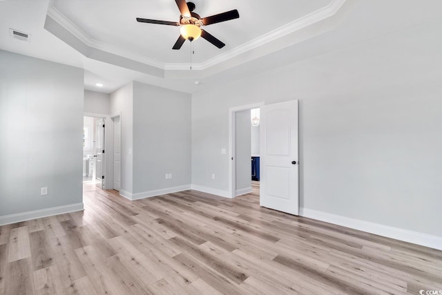 unfurnished room featuring crown molding, ceiling fan, a tray ceiling, and light hardwood / wood-style flooring