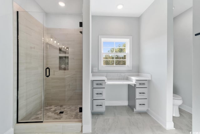 bathroom featuring toilet and a shower with shower door