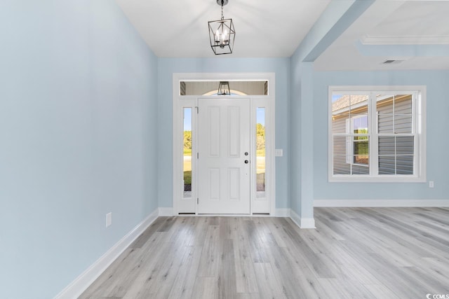 foyer entrance featuring an inviting chandelier and light wood-type flooring