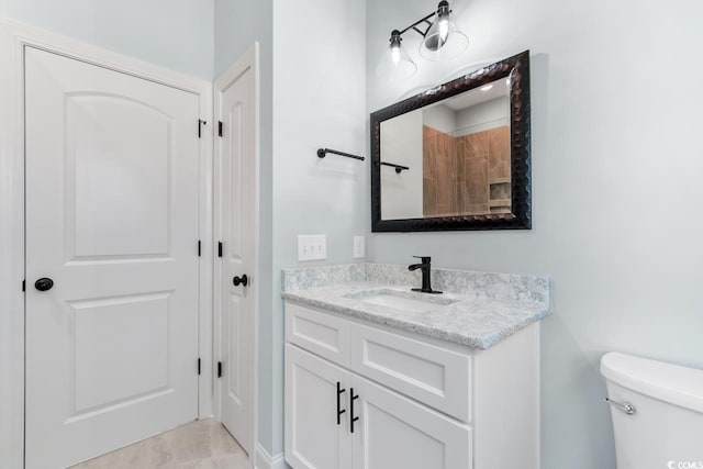 bathroom featuring vanity, tile patterned flooring, and toilet