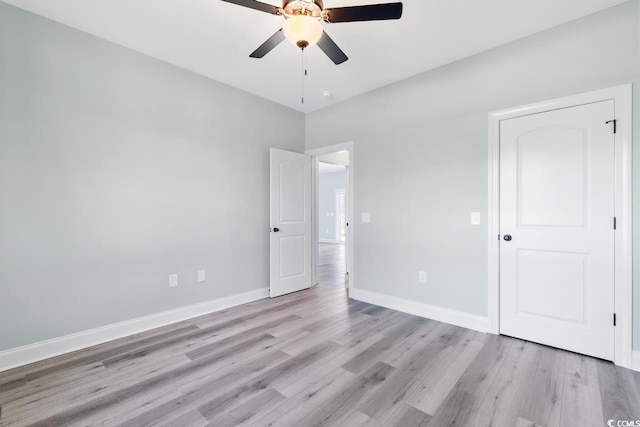 unfurnished bedroom with ceiling fan and light wood-type flooring