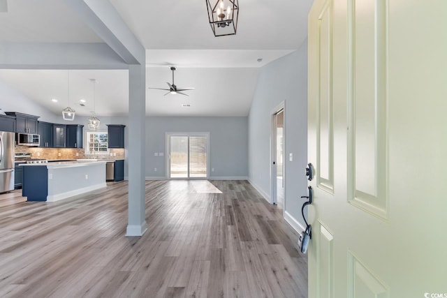 foyer featuring hardwood / wood-style flooring, vaulted ceiling, and ceiling fan