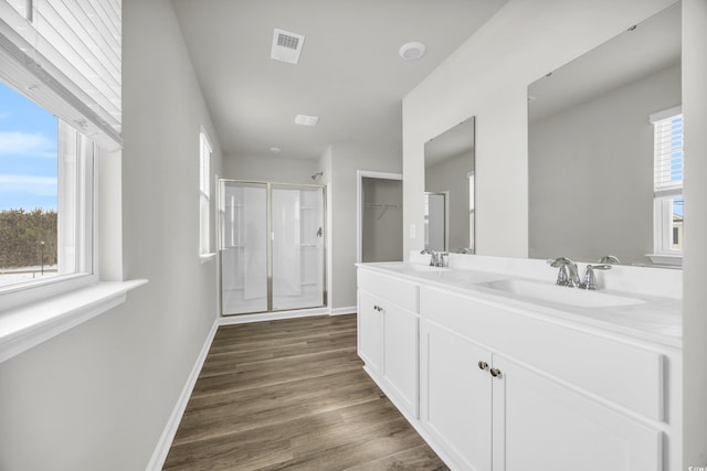 bathroom featuring vanity, a healthy amount of sunlight, hardwood / wood-style floors, and walk in shower