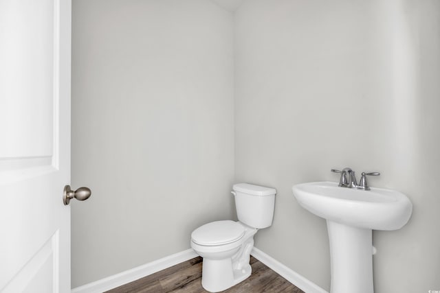 bathroom with hardwood / wood-style flooring, sink, and toilet