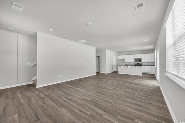 unfurnished living room with dark hardwood / wood-style floors