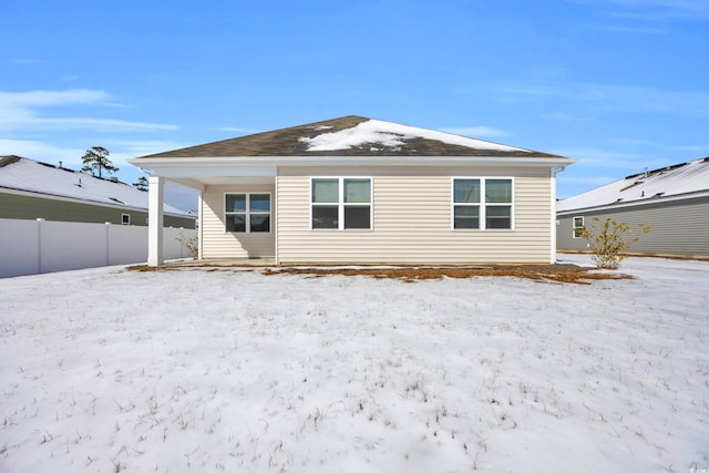 snow covered property with fence