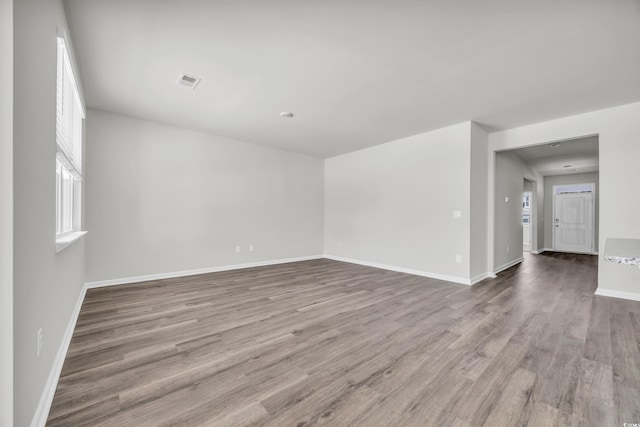 empty room with baseboards, visible vents, and light wood-style floors