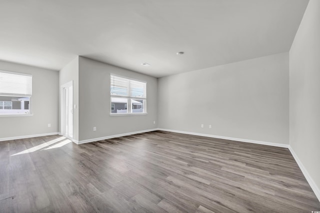 unfurnished room with baseboards and wood finished floors