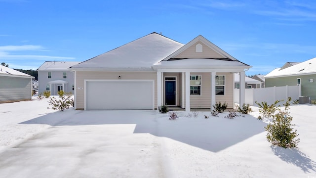 view of front of home featuring cooling unit, driveway, an attached garage, and fence