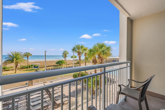 balcony featuring a beach view and a water view