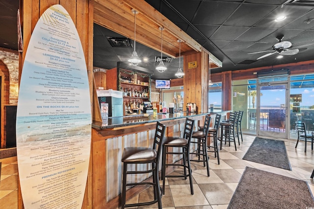 bar with light tile patterned flooring, pendant lighting, and ceiling fan