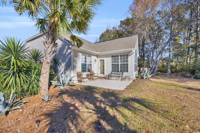 back of property with a patio and a yard