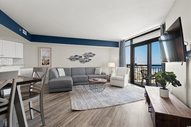 living room with expansive windows and light hardwood / wood-style floors