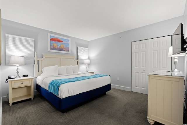 bedroom with dark carpet and a closet