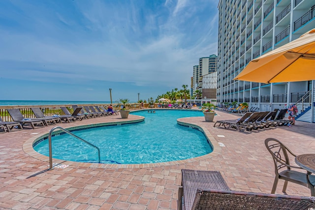 view of pool featuring a patio area and a water view