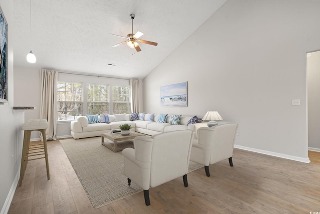 living room featuring wood-type flooring, high vaulted ceiling, and ceiling fan