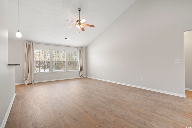 spare room with high vaulted ceiling, light hardwood / wood-style floors, and ceiling fan