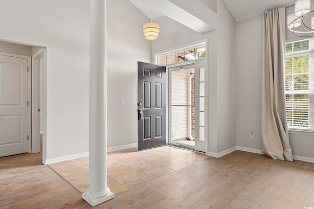 foyer featuring lofted ceiling, a notable chandelier, and light wood-type flooring