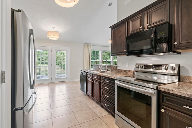 kitchen with plenty of natural light, sink, light tile patterned floors, and black appliances