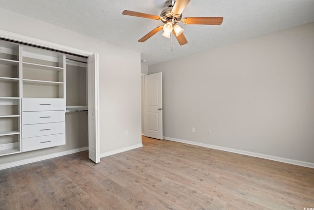 unfurnished bedroom with a textured ceiling, a closet, ceiling fan, and light wood-type flooring