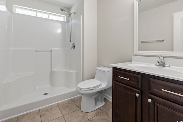 bathroom featuring walk in shower, vanity, toilet, and tile patterned flooring