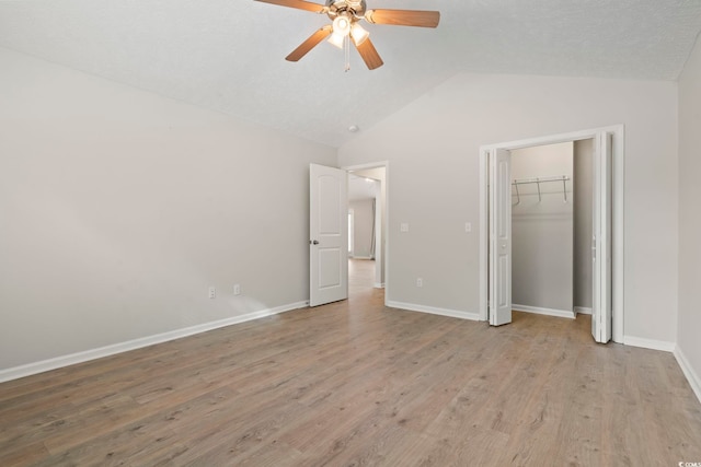 unfurnished bedroom with ceiling fan, lofted ceiling, light hardwood / wood-style floors, and a closet