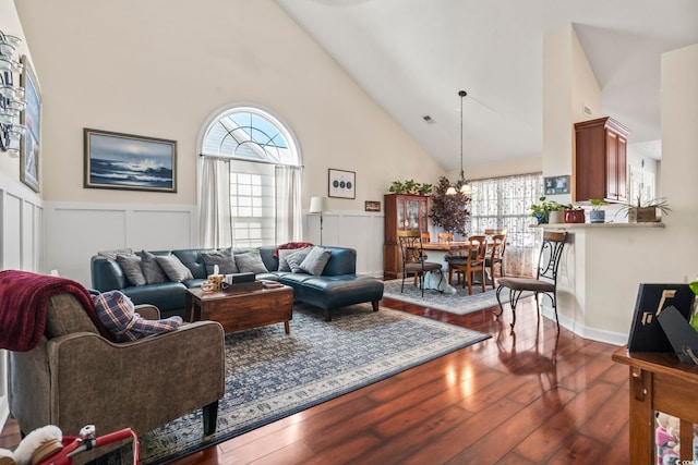 living room with dark hardwood / wood-style floors, high vaulted ceiling, and a wealth of natural light