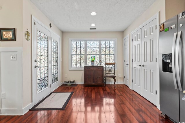 doorway to outside with dark hardwood / wood-style floors and a textured ceiling