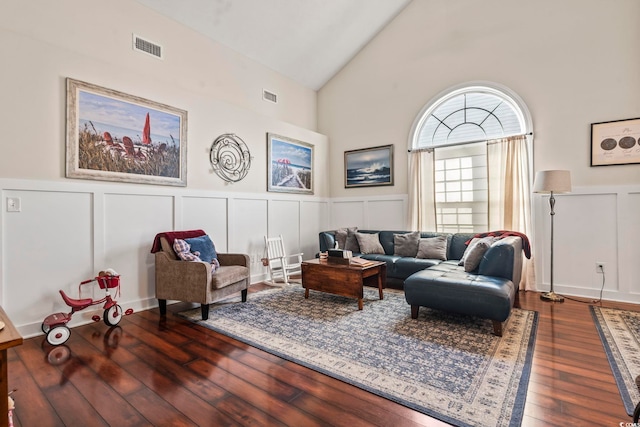 living room with high vaulted ceiling and dark hardwood / wood-style floors