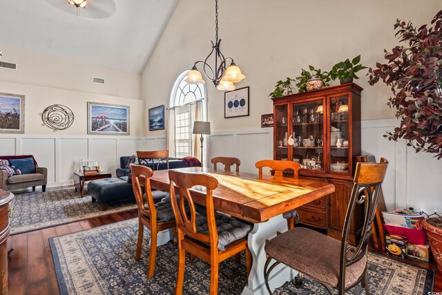 dining area with wood-type flooring and high vaulted ceiling