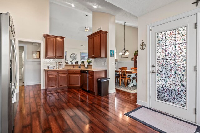 kitchen with dark wood-type flooring, appliances with stainless steel finishes, tasteful backsplash, and pendant lighting