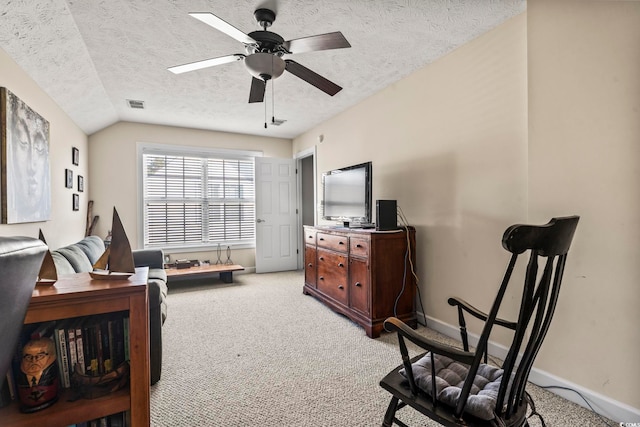 interior space with vaulted ceiling, carpet floors, ceiling fan, and a textured ceiling