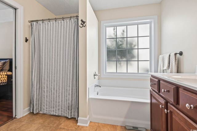 bathroom with vanity, tile patterned floors, and a tub to relax in