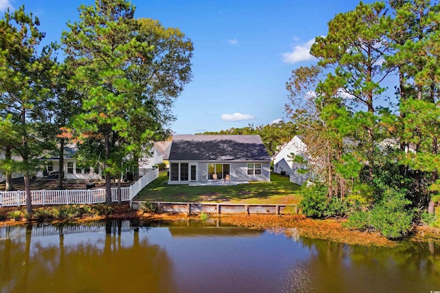 rear view of property featuring a lawn and a water view