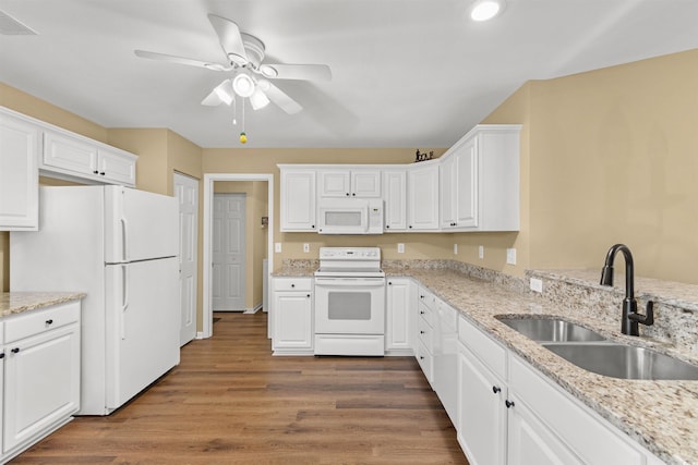 kitchen featuring sink, white cabinets, dark hardwood / wood-style flooring, light stone countertops, and white appliances