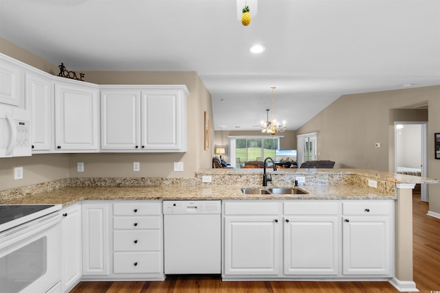 kitchen with sink, white cabinetry, kitchen peninsula, white appliances, and light stone countertops