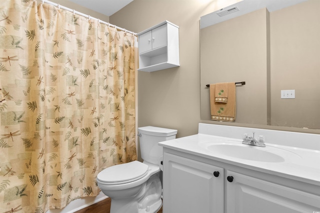 bathroom featuring vanity, toilet, and walk in shower