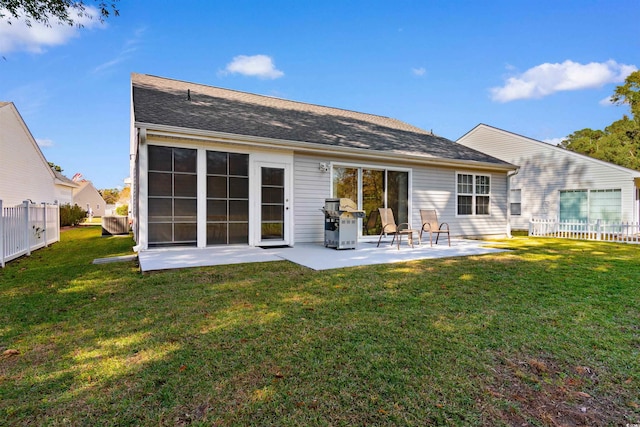 rear view of property featuring a lawn and a patio area