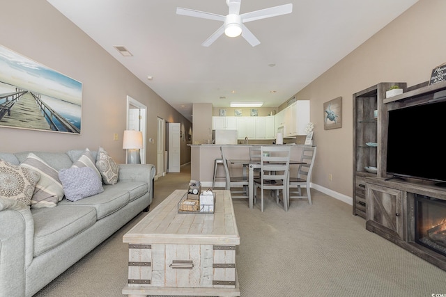 carpeted living room with ceiling fan