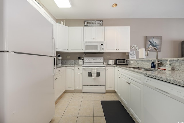 kitchen with light tile patterned flooring, sink, white cabinets, and white appliances