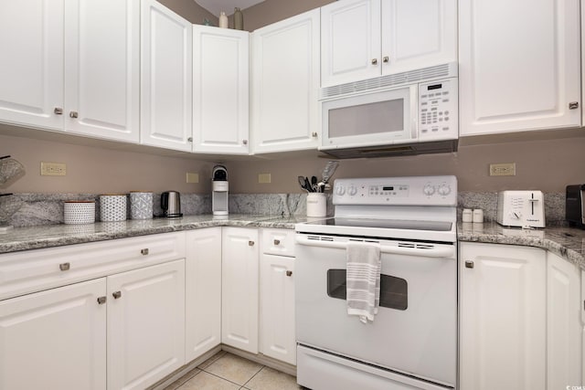 kitchen featuring stone countertops, light tile patterned floors, white cabinets, and white appliances