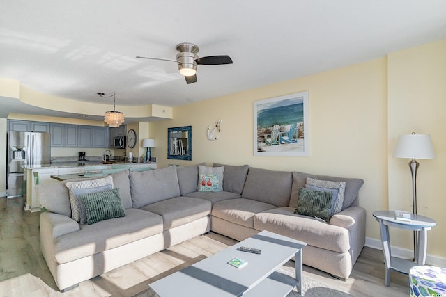 living room featuring ceiling fan and light wood-type flooring