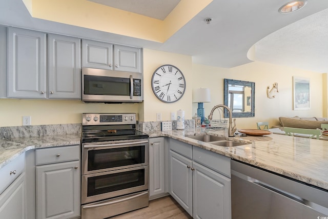 kitchen featuring gray cabinetry, sink, and stainless steel appliances