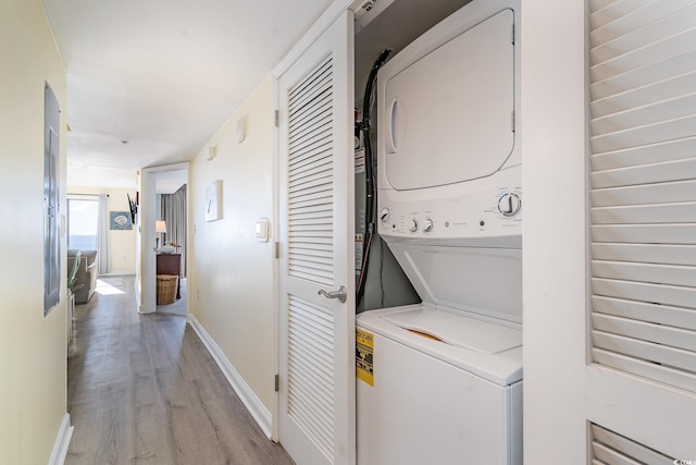 clothes washing area with stacked washer / dryer and light hardwood / wood-style floors