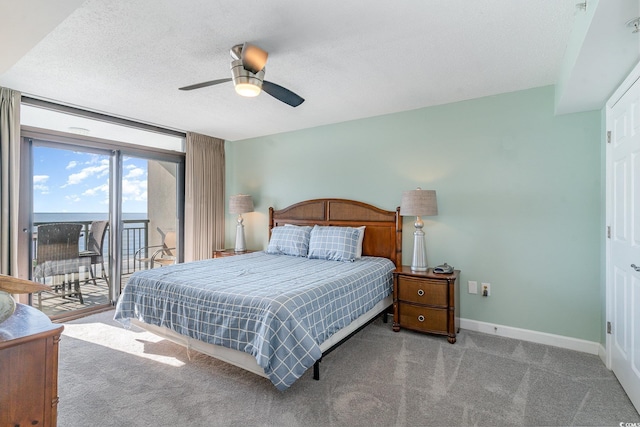 bedroom featuring a water view, ceiling fan, carpet, and access to outside