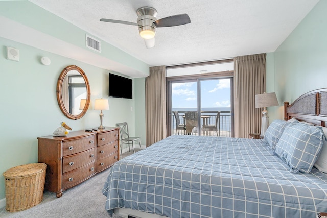 bedroom featuring a textured ceiling, access to outside, light colored carpet, and ceiling fan