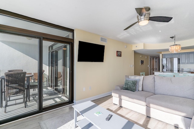 living room with light hardwood / wood-style floors and ceiling fan