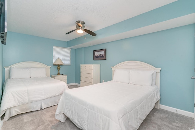 carpeted bedroom featuring a textured ceiling and ceiling fan