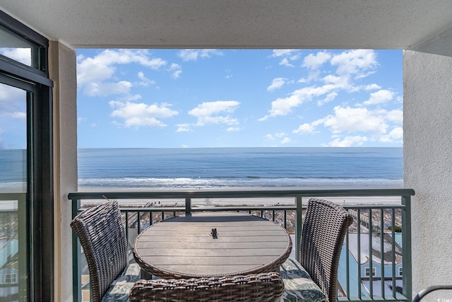 balcony featuring a water view and a view of the beach