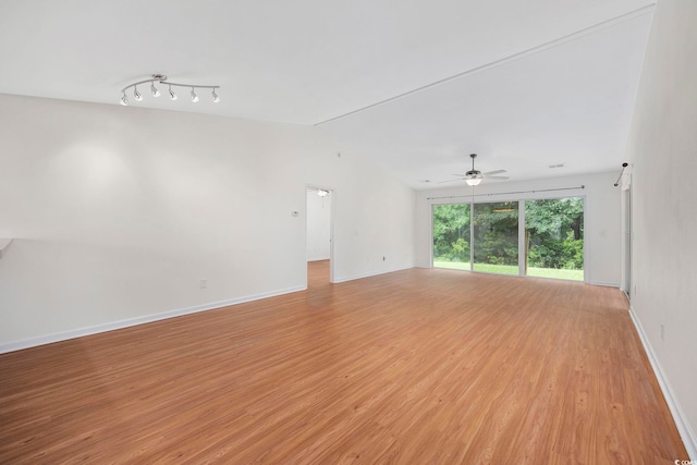 spare room featuring lofted ceiling, light hardwood / wood-style floors, and ceiling fan